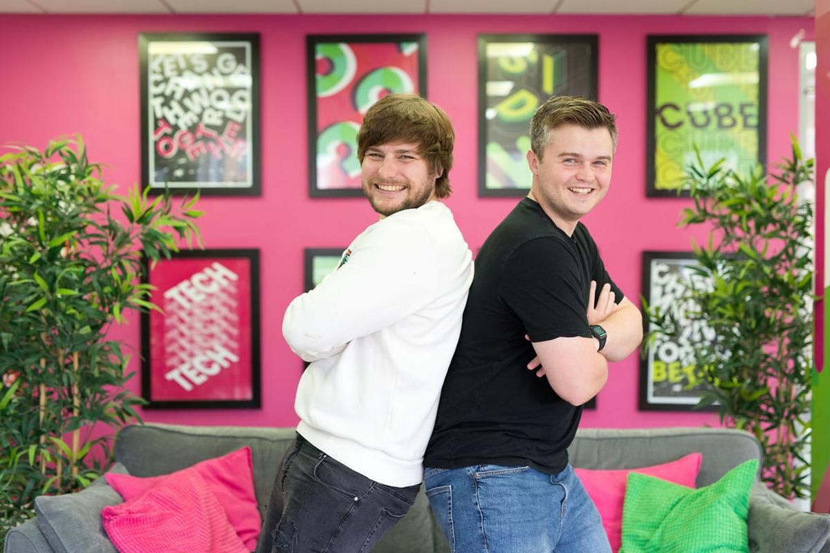 Kev and Tom posing back to back and laughing.