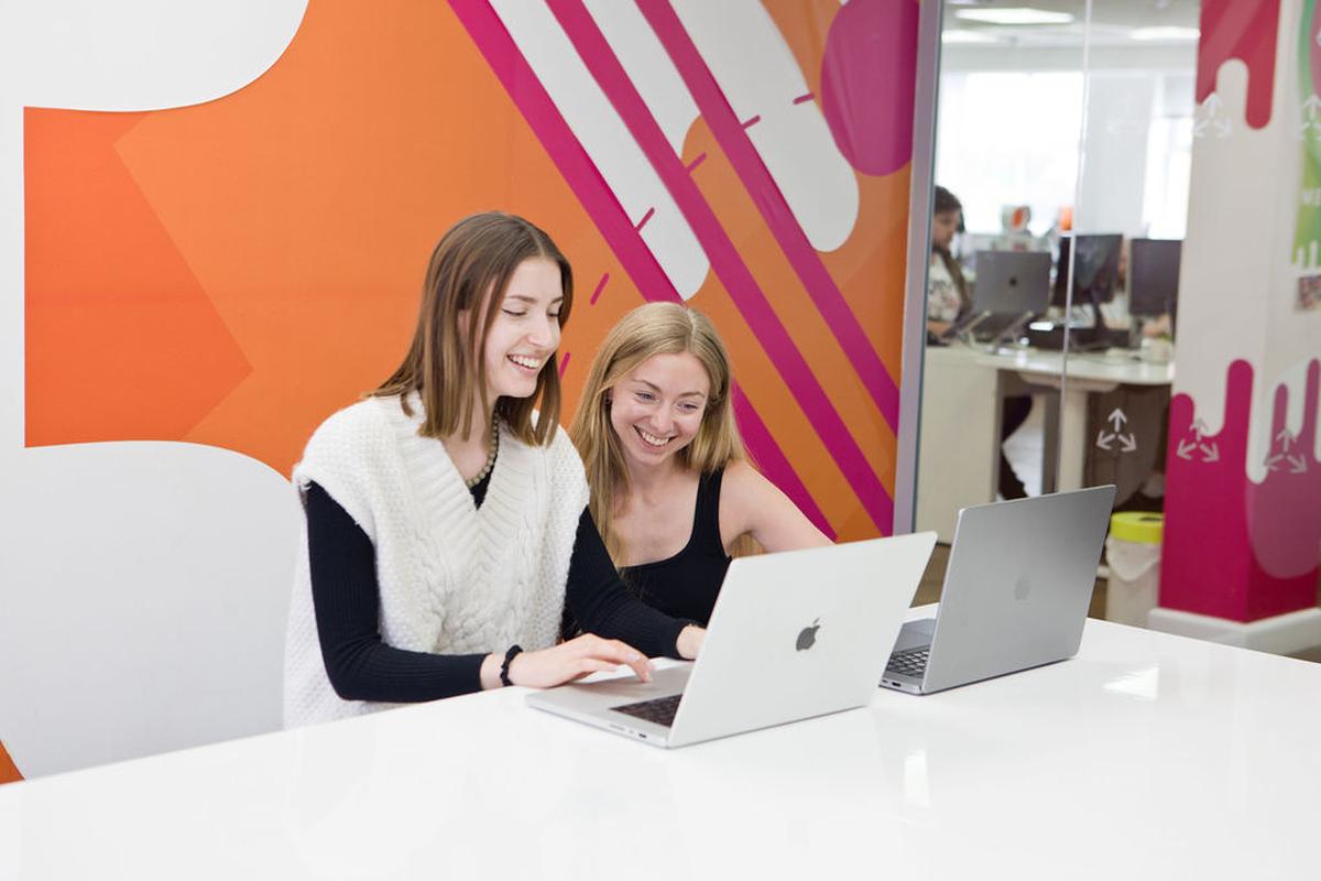Two of our Cubes working together with their laptops in one of our meeting rooms.