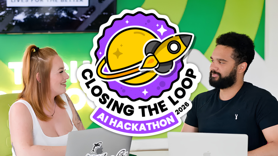 Two people sitting with laptops, smiling at each other. A "Closing the Loop AI Hackathon 2026" logo featuring a rocket and planet is superimposed.