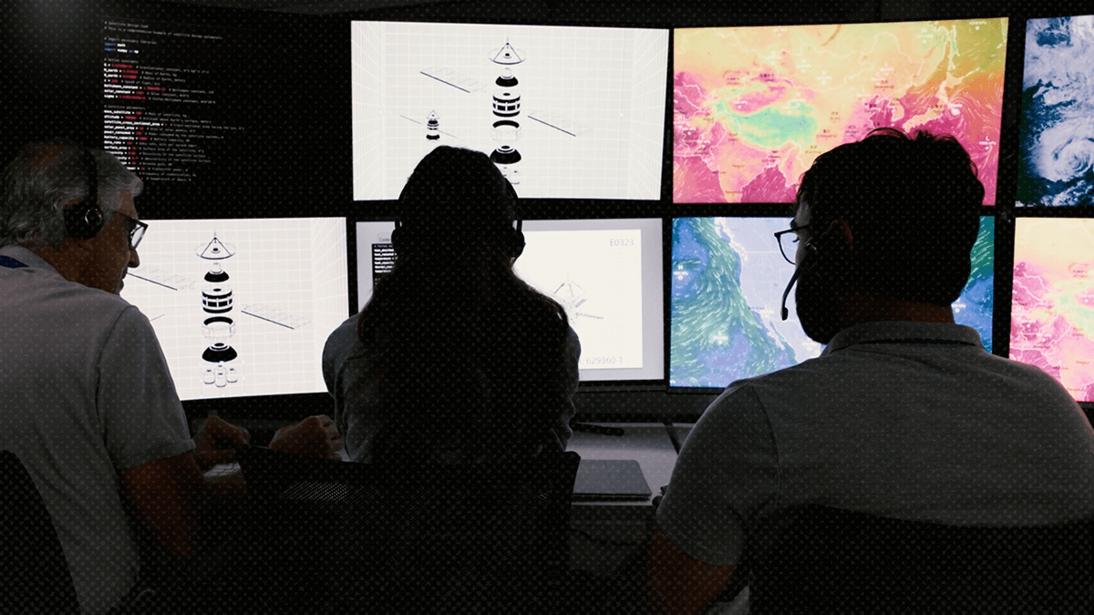 Three people looking at multiple computer screens and observing the weather. Their backs are to the camera.